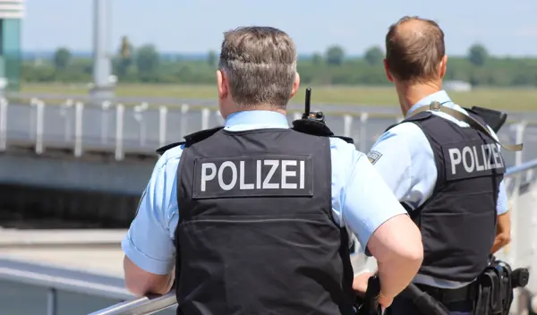 Foto met twee Duitse politiemannen die langs een weg staan