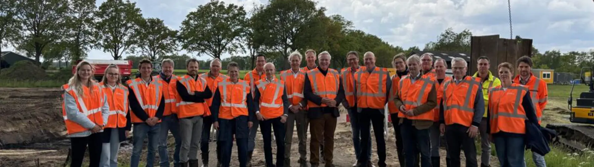 Groepsfoto Projectbezoek DIWA met iedereen gekleed in oranje veiligheidshesjes